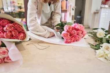 Florist woman creates beautiful bouquet of mixed flowers with varietal carnations, peony and eustoma. European floral shop concept. Handsome fresh bunch. Education, master class and floristry courses