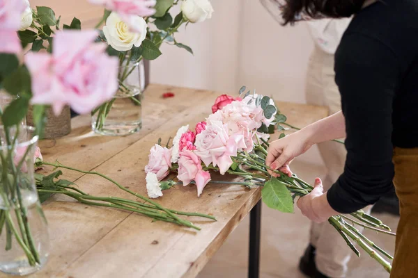 Florist woman creates beautiful bouquet of mixed flowers with varietal carnations, peony and eustoma. European floral shop concept. Handsome fresh bunch. Education, master class and floristry courses