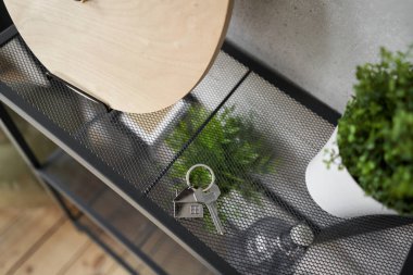 Key with house shaped keychain on table . Modern light apartment interior. Mortgage concept. Real estate, moving home or relating property. High quality photo