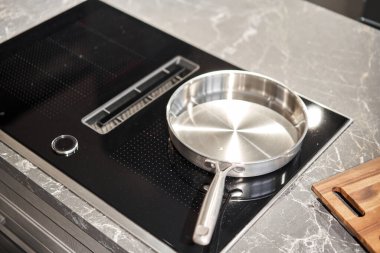 Modern mutfakta siyah indüksiyon hob üzerine yeni yemek takımı. Tencere ve tava mutfakta, indüksiyon hobında. Elektrikli soba. Yüksek kalite fotoğraf