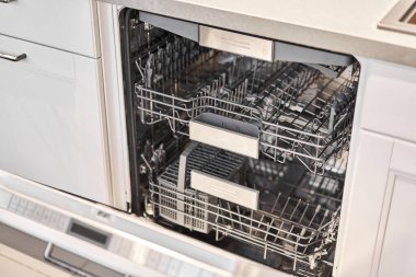 Empty Built-in dishwashers with opened door. Home appliance dishwasher machine in modern kitchen. White tone and clean kitchen. High quality photo