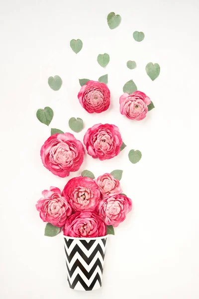 The concept of a flower shop and coffee shop. A coffee cup and flowers. Coffee to go. Petals of flowers, roses and ranunculus. Valentines day romantic background . Space for text. High quality photo