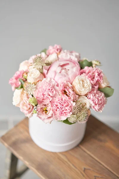 Beautiful spring bouquet in round box. Arrangement with various flowers. The concept of a flower shop. A set of photos for a site or catalogue. Work florist