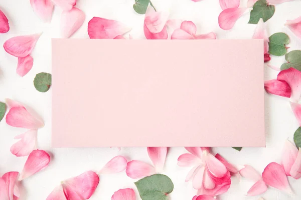 stock image Love letter. white card with pink paper envelope mock up. Petals of flowers, roses and ranunculus. Valentines day romantic background . High quality photo