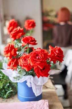 Florist woman creates beautiful bouquet of mixed flowers with varietal carnations, peony and eustoma. European floral shop concept. Handsome fresh bunch. Education, master class and floristry courses