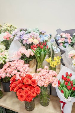 Flower shop concept. Different varieties fresh spring flowers in refrigerator room for flowers. Bouquets on shelf, florist business. High quality photo