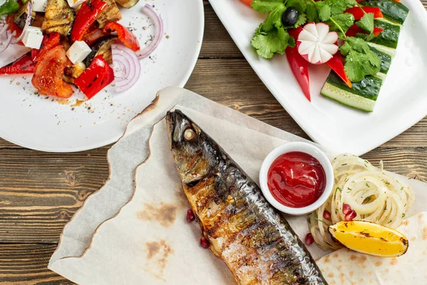 ızgara uskumru ve taze sebze salata. Rustik bir masada ahşap bir gemide hizmet. Barbekü Restoran Menü, bir dizi farklı etler anf balık fotoğrafları.