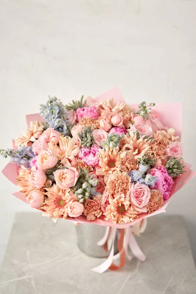Beautiful large bouquet of mixed flowers. Handsome fresh bouquet in vase on table. Small flower shop and Flowers deliver