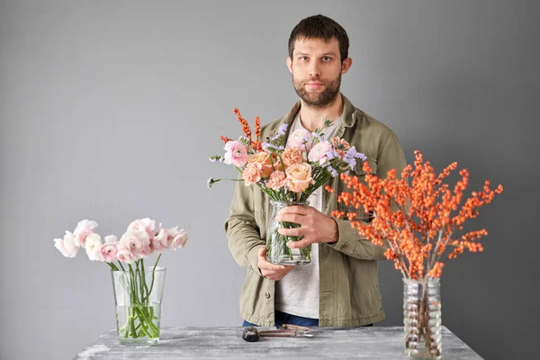 Portrait of a Male florist. Flowers bunch, set for home. Fresh cut flowers for decoration home. European floral shop. Delivery fresh cut flower