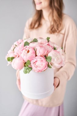 Bir kadının elinde iki buket pembe şakayık. Katalog ya da internet mağazası için güzel şakayık çiçekleri. Çiçek dükkanı konsepti. Taze kesilmiş güzel bir buket. Çiçek teslimatı.