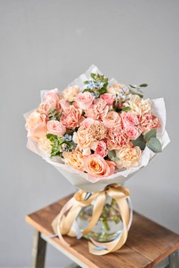 Ahşap masada güzel bir buket karışık çiçek. Çiçek dükkanı konsepti. Güzel taze kesilmiş buket.