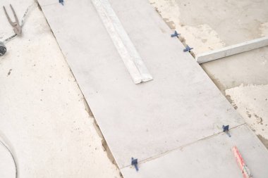 Evdeki yemek odasının tamiri, mutfak yeri, zemin kaplaması. Boş bir odada tamir işlemi. Tasarım için içi boş, gri beton duvar