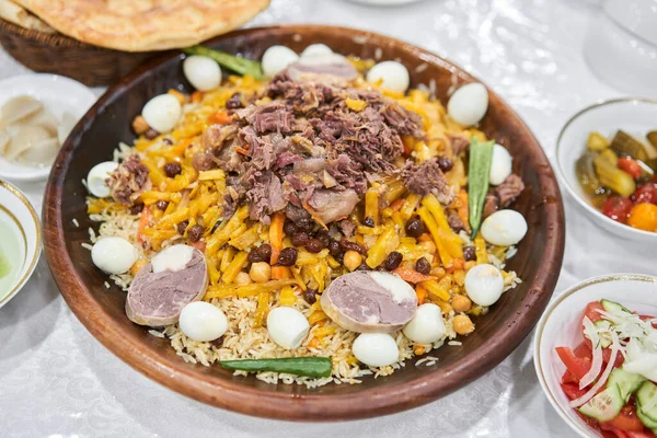 一种传统的乌兹别克菜叫做 皮拉夫 米饭桌上放着肉 胡萝卜 鹌鹑蛋和意大利面 三个人的一份子高质量的照片 — 图库照片