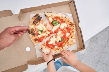 Pizza teslimatı. Ahşap bir arka planda karton bir kutuda pişirmek. Napoli restoranında geleneksel odun yakma fırınında lezzetli bir pizza pişirdim. Yüksek kalite fotoğraf