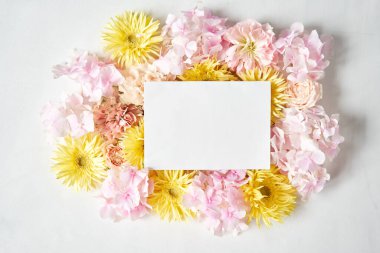 Mesaj için beyaz kart. Çiçek yaprakları, karanfil, gerbera, ortanca, gül. Sevgililer Günü romantik geçmişi. Kelimeler için yer var. Aşk mektubu. Yüksek kalite fotoğraf