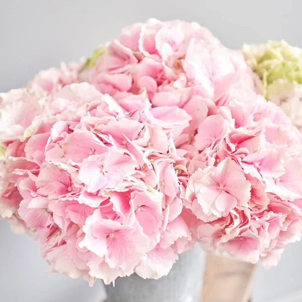 Beautiful pink hydrangea flowers in a vase on a table . Bouquet of light pink flower. Decoration of home. Wallpaper and background. fuchsia color. High quality photo