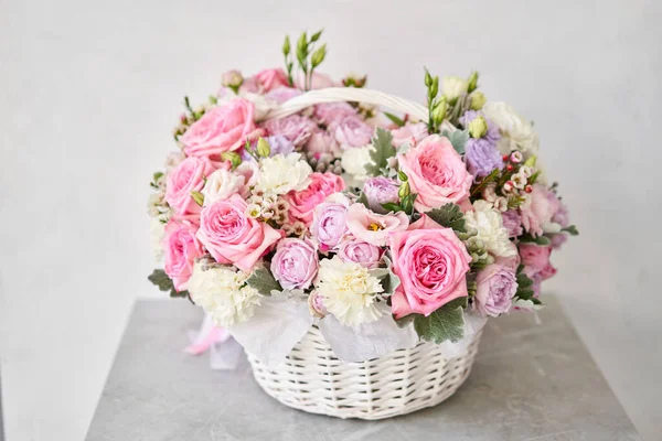 Flower arrangement in Wicker basket. Beautiful bouquet of mixed flowers on a marble table. Floral shop concept . Handsome fresh bouquet. Flowers delivery. High quality photo
