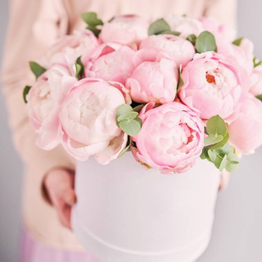 Kadınların elinde bir buket pembe şakayık. Çiçek teslimatı. Tatil hediyesi olarak güzel bir buket çiçek kaliteli bir fotoğraf.