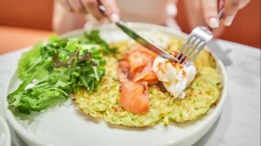 Kız haşlanmış yumurta keser ve yumurta sarısı akar. Kabaklı börek, somon ve yumurtalı avokado kreması. Sağlıklı kahvaltı, protein. Restoran yemeği. Hareketi Durdur