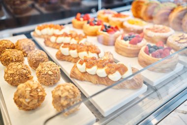 Pastanenin vitrininde çeşitli taze hamur işleri var. Bademli kruvasan bir kafede diğer hamur işlerinin yanında taze ve sıcaktır. Bir İtalyan restoranının içi. Yüksek kalite fotoğraf