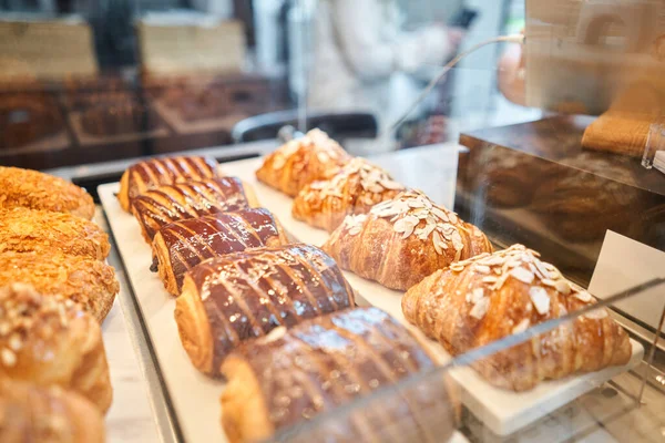 stock image A variety of fresh pastries in the bakery window. almond croissant is fresh and hot in a cafe next to other types of pastries. The interior of an Italian restaurant. High quality photo