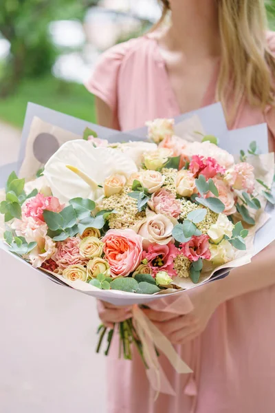 Beautiful bouquet with peonies flowers in woman hand. Floral shop concept . Beautiful fresh cut bouquet. Flowers delivery. High quality photo