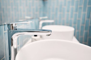 Lavaboda iki lavabo, şık dekorasyonların yanında. Güzel bir lavabo, aynanın yanında metal bir musluk ve el havlularıyla dolu bir raf.. 