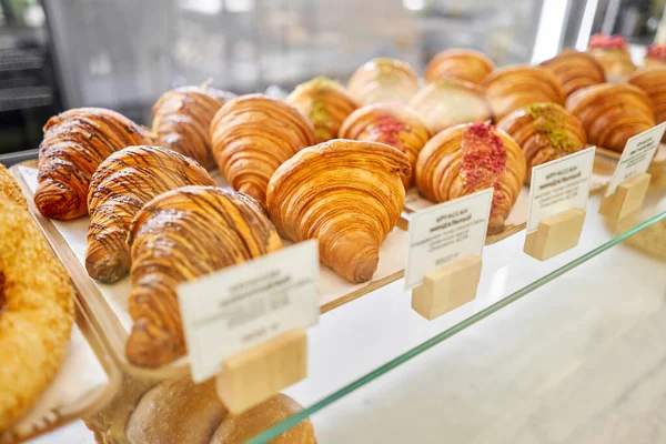 面包店橱窗里有各种新鲜的糕点 杏仁羊角面包是新鲜而热的在咖啡店旁边的其他类型的糕点 意大利餐馆的内部 高质量的照片 — 图库照片