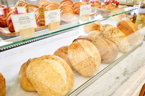 パン屋さんのカウンターでパンの種類が違う 新鮮なパンカウンター ケーキ パンの異なる種類の近代的なパン屋 高品質の写真 — ストック写真