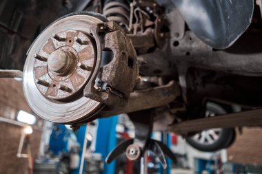 Paslı disk frenler, arabanın önü. Garajdaki eski fren diskini yenisiyle değiştir. Oto tamircisi tamir ediliyor. Yüksek kalite fotoğraf