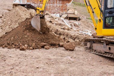 Kazıcı dağlık arazide çalışıyor. İletişim için siper kazıyor. Su ve elektrik. Dağların eteğinde. Bir yolun tamiri ve genişletilmesi. Yüksek kalite fotoğraf