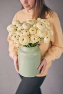 Bir buket soluk pembe ranunculus çiçeği, sıradan Hanoi. Kadın elinde vazoda İran düğün çiçeği. Çiçekçi dükkanındaki bir çiçekçinin işi. Yüksek kalite fotoğraf