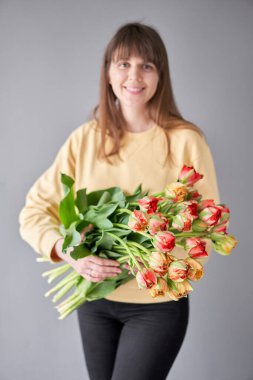 Lale Gudoshnik kadının elinde. Elinde bir buket kırmızı lale. Bir demet taze bahar çiçeği. Yüksek kalite fotoğraf