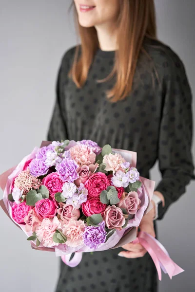 Florist woman creates beautiful bouquet of mixed flowers. European floral shop concept. Handsome fresh bunch. Education, master class and floristry courses. Flowers delivery.. High quality photo
