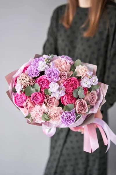 Florist woman creates beautiful bouquet of mixed flowers. European floral shop concept. Handsome fresh bunch. Education, master class and floristry courses. Flowers delivery.. High quality photo