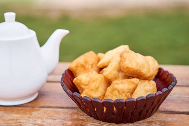 Çaydanlıklı çay ve lezzetli Ulusal Kazak hamur işleri baursak. Dağları gören bir sokak kafesi kızartma tavasında kızgın yağda kızartılmış hamur. Yüksek kalite fotoğraf