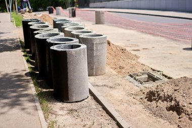 Fırtınalı su sistemi için beton rögar kapakları ve drenaj boruları döşemek. İnşaat alanındaki beton rögar yapısına bir hendek drenajı bağlamak. Fırtına suyu ve yeraltı tesisleri inşa edin. Yüksek