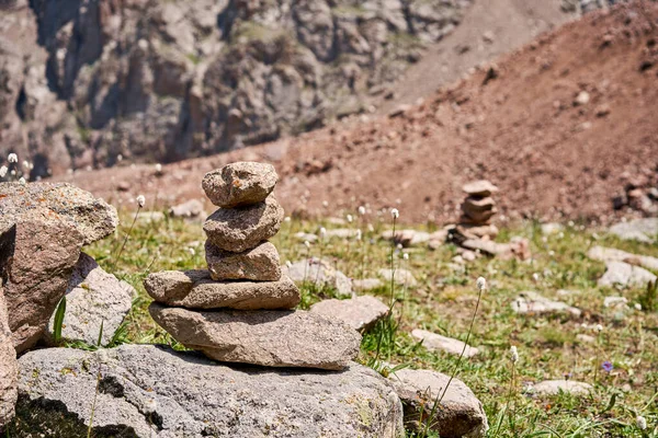 Zen dengeli taşlar yüksek dağlarda istiflenir. Resimli bir dağ vadisine karşı taş piramitleri. Moraine Kazakistan 'ın dağlık kesimlerinde. Yüksek kalite fotoğraf