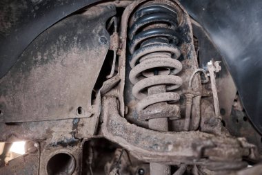 A car mechanic inspects brake discs and pads with a flashlight. Car on a repair stand. Technical service station for car. High quality photo