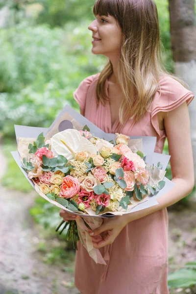 Beautiful bouquet with peonies flowers in woman hand. Floral shop concept . Beautiful fresh cut bouquet. Flowers delivery. High quality photo