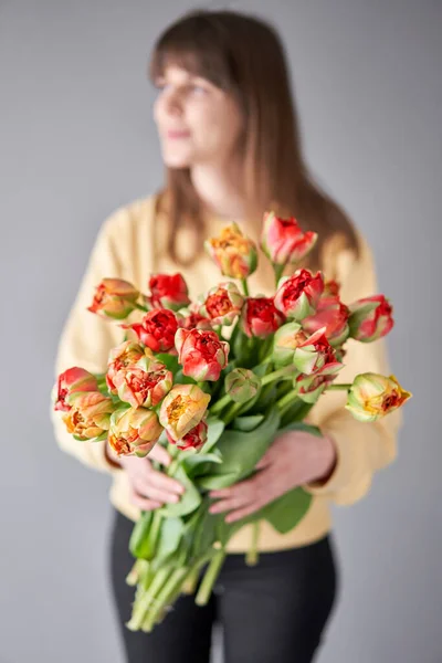 Tulip Gudoshnik in woman hand. Spring bouquet of red tulips in hands. Bunch of fresh cut spring flowers. High quality photo