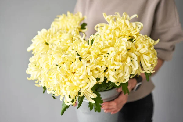 Mono bouquet of chrysanthemum in metal vase. European floral shop. the work of the florist at a flower shop. Delivery fresh cut flower