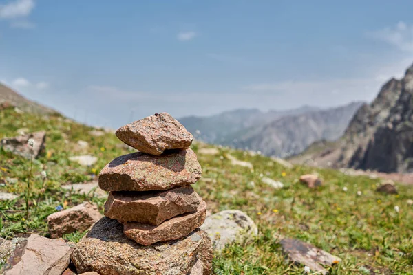 Zen dengeli taşlar yüksek dağlarda istiflenir. Resimli bir dağ vadisine karşı taş piramitleri. Moraine Kazakistan 'ın dağlık kesimlerinde. Yüksek kalite fotoğraf