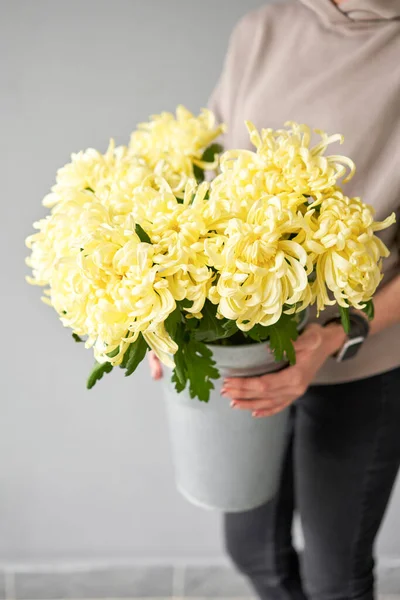 Mono bouquet of chrysanthemum in metal vase. European floral shop. the work of the florist at a flower shop. Delivery fresh cut flower