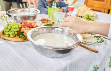 Master sınıfı ve peynir tatma. Kadınlar peynir yapar. Enzim ve başlangıç kültürü süte metal bir kapta eklenir. Süt katlama süreci, ev yapımı, iş, girişimci. Yüksek