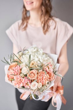 Küçük güzel buketler karışık çiçekler kadının elinde. Çiçek dükkanı konsepti. Taze kesilmiş güzel bir buket. Çiçek teslimatı. Yüksek kalite fotoğraf