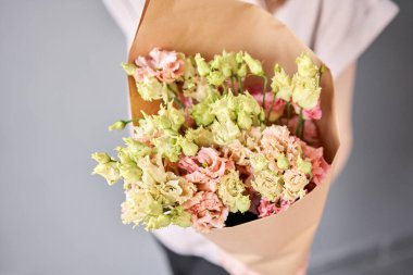 Küçük güzel buketler karışık çiçekler kadının elinde. Çiçek dükkanı konsepti. Taze kesilmiş güzel bir buket. Çiçek teslimatı. Yüksek kalite fotoğraf