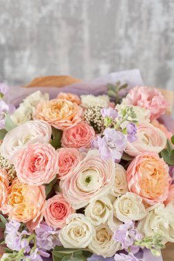 Kadının elinde küçük, güzel bir buket karışık çiçek. Çiçek dükkanı konsepti. Taze kesilmiş güzel bir buket. Çiçek teslimatı. Yüksek kalite fotoğraf