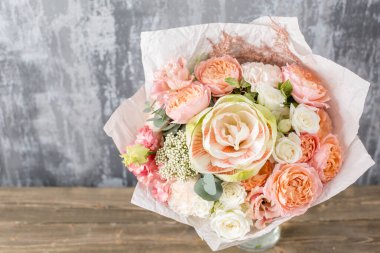 Kadının elinde küçük, güzel bir buket karışık çiçek. Çiçek dükkanı konsepti. Taze kesilmiş güzel bir buket. Çiçek teslimatı. Yüksek kalite fotoğraf