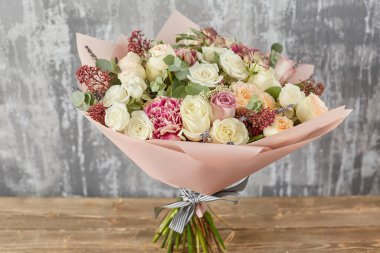 Kadının elinde küçük, güzel bir buket karışık çiçek. Çiçek dükkanı konsepti. Taze kesilmiş güzel bir buket. Çiçek teslimatı. Yüksek kalite fotoğraf